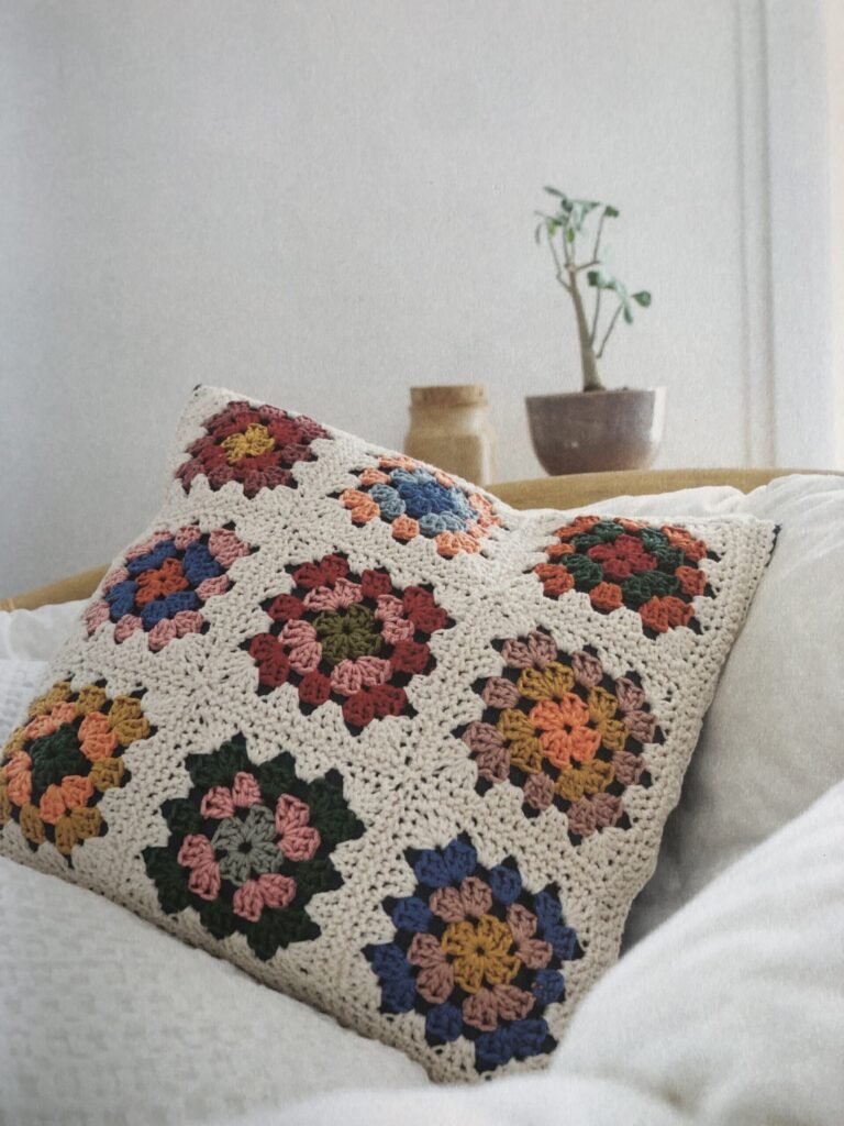 Een zacht gehaakt kussen in een rustige, gezellige zetel met natuurlijke kleuren